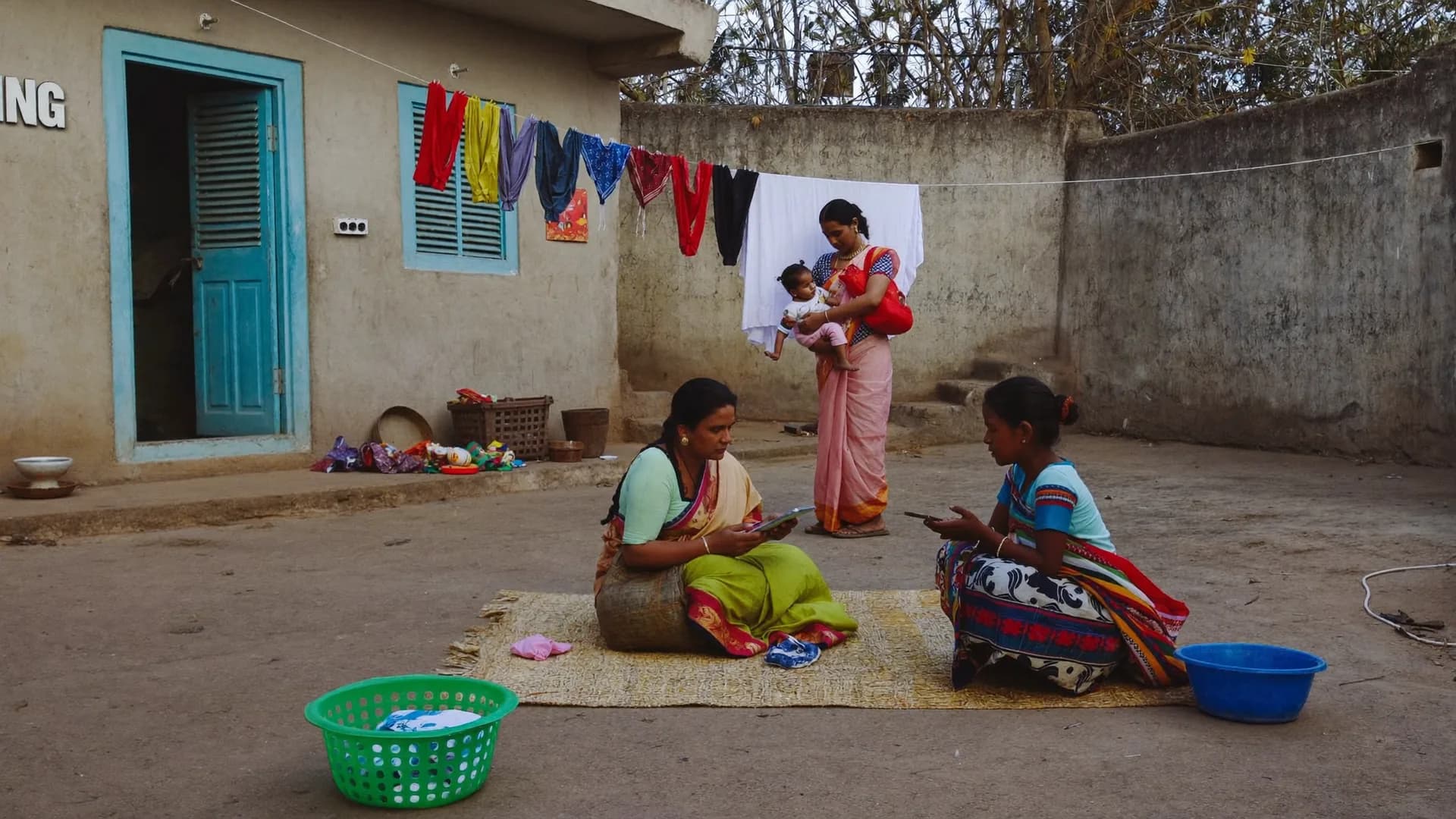 आँगनवाड़ी के बाहर महिलाओं के समूह से बात करती NGO कार्यकर्ता